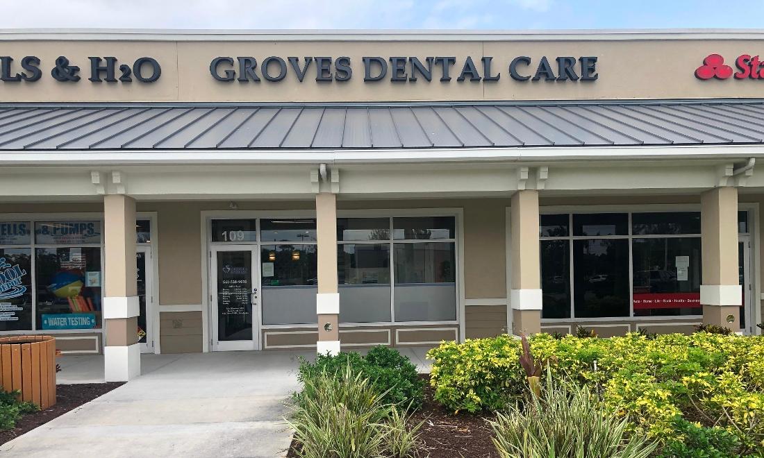 Exterior storefront of Groves Dental Care dental office with entrance and signage.